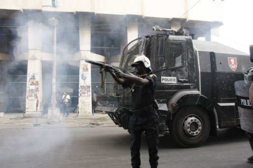 Un policier anti-émeute lance des gazs lacrymogènes contre des membres du mouvement M23 à Dakar, le 15 février 2012 Les forces de l’ordre ont dispersé à la grenade lacrymogène mercredi dans le centre de Dakar une manifestation interdite de l’opposition qui tentait une nouvelle fois de protester contre la candidature du président Wade à la présidentielle du 26 février. AFP - Mamadou Toure Behan