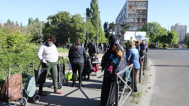 Des habitants font la queue pour recevoir des colis alimentaires, le 22 avril 2020, à Clichy-sous-Bois. Ludovic Marin / AFP.