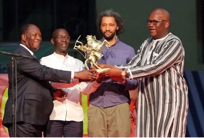 Photo- Alain Gomis entouré de Roch M. C. KABORE et d'Alassane Ouatara recevant l'Etalon d'or de Yennenga du Fespaco 2017